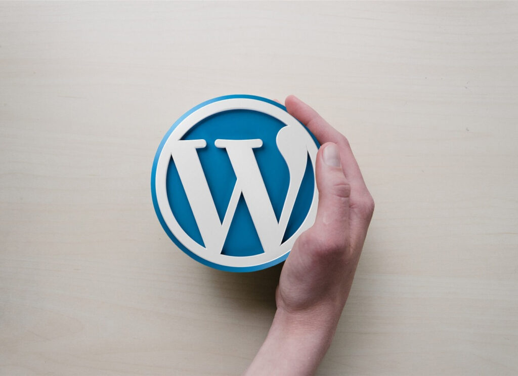 wordpress logo surrounded by a hand
