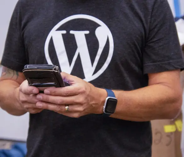 man with a WordPress t-shirt using a smartphone