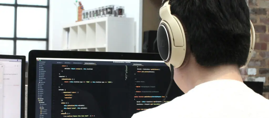 A WordPress developer with headphones on reviewing code