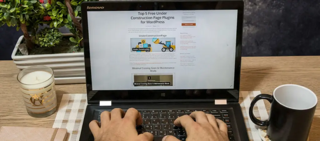 someone using a Lenovo computer to write an article about WordPress maintenance page plugins