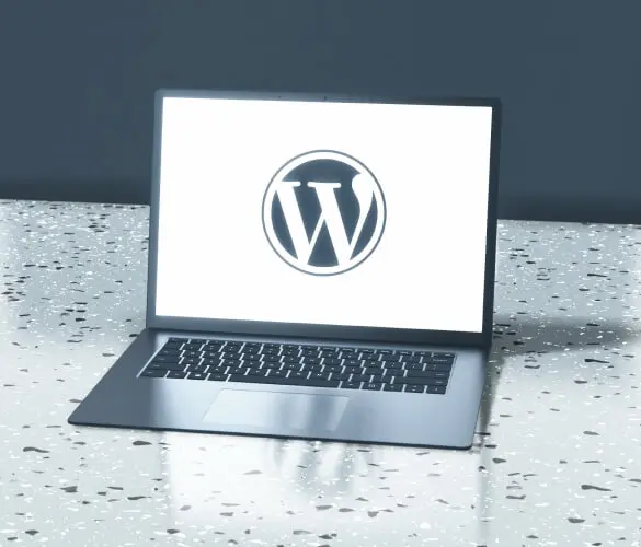 a laptop over a counter. The screen displays the WordPress logo