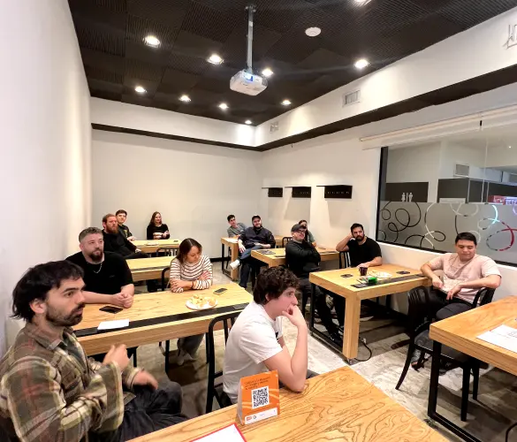 a group of team members sitting on chairs in front of their desks in a meeting room