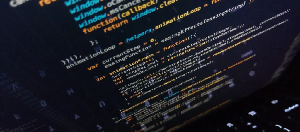 overhead shot of a laptop screen displaying colorful javascript code