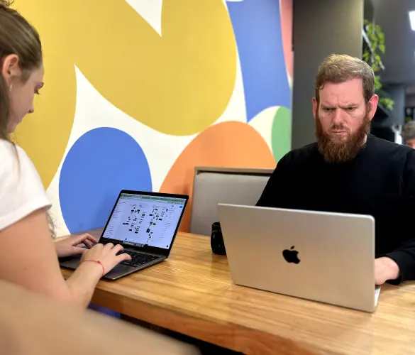 two WordPress developers sitting opposite to each other on a table