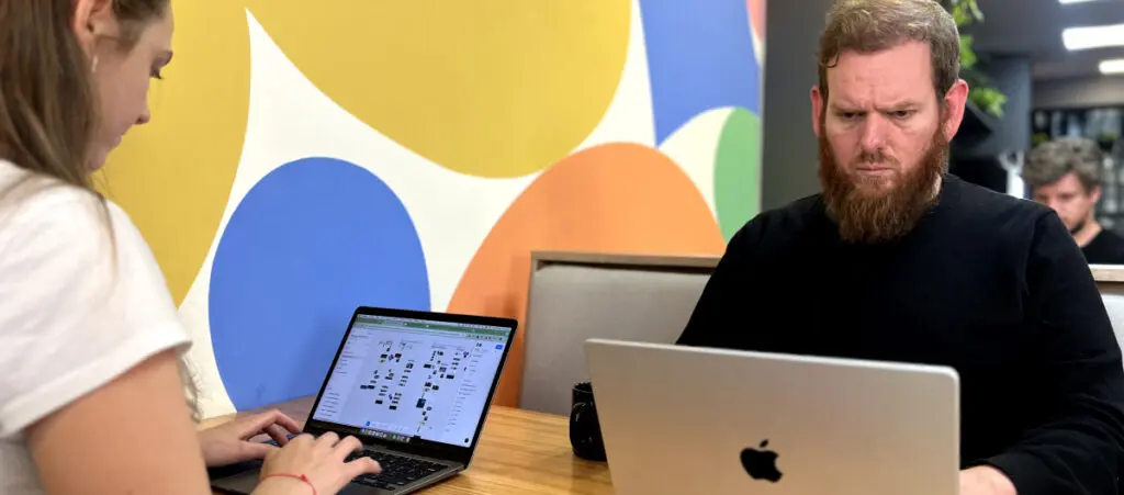 two WordPress developers sitting opposite to each other on a table