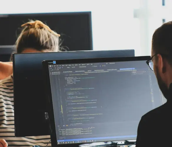 a WordPress tech lead and developer writing code in front of a large monitor