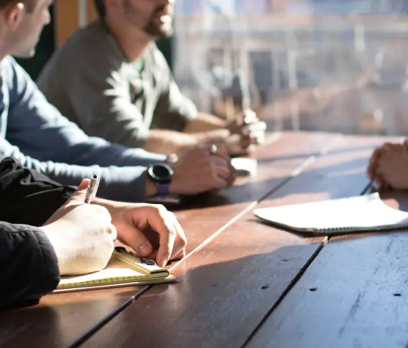 several people sitting together around a table discussing business