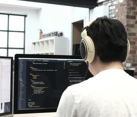 a WordPress developer writing code with a large screen in front of him