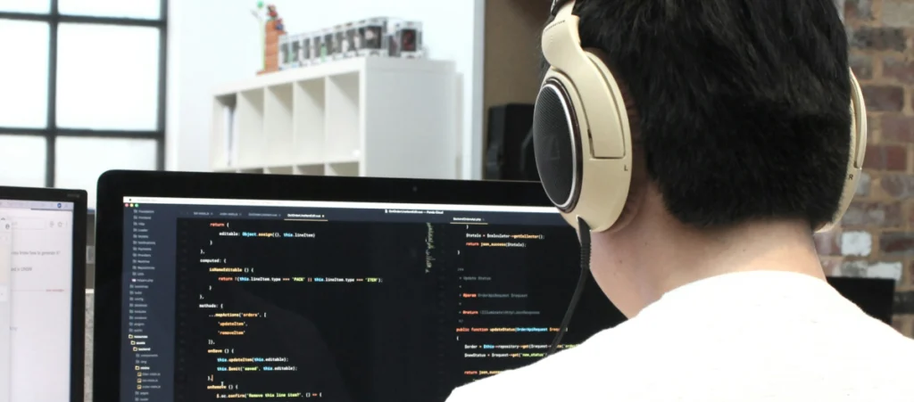 a WordPress developer writing code with a large screen in front of him