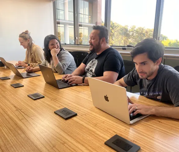 a group of WordPress development agency team members working on the same table