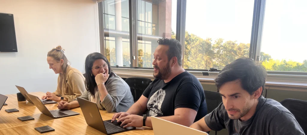 a group of WordPress development agency team members working on the same table