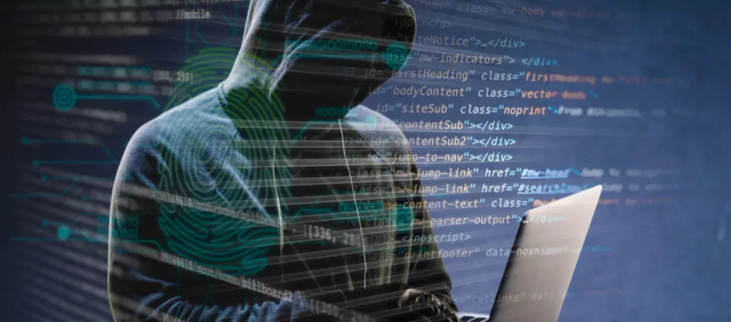 hooded man hacking a computer